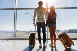 Par som tittar på ett startande flygplan på flygplatsen relaterat till flight tracker 24